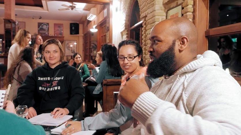 Group of LR study abroad students gather in cafe to discuss their experience